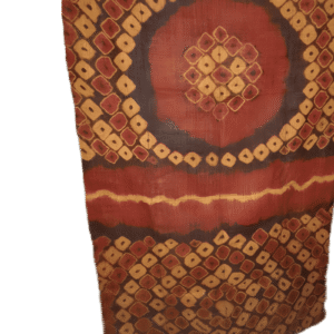 Tissu traditionnel africain avec motifs géométriques rouges, oranges et noirs.