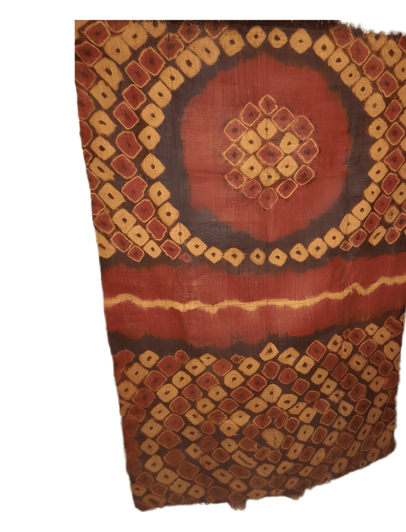 Tissu traditionnel africain avec motifs géométriques rouges, oranges et noirs.